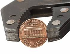 wrench squeezing penny