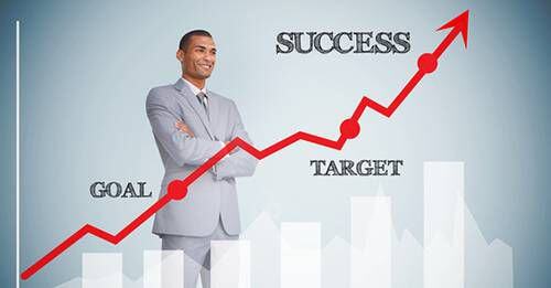 Businessman looking at a chart showing increasing success